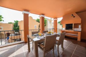 a dining room with a table and chairs on a balcony at Ona Lomas Village - La Manga Club in La Manga del Mar Menor