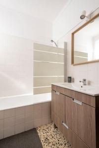 a bathroom with a sink and a tub and a mirror at Casa Alto da Serra Sesimbra in Sesimbra