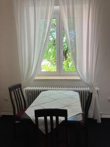 スタレー・ムニェストにあるApartmány Windyの窓、テーブル、椅子が備わるベッドルーム1室が備わります。