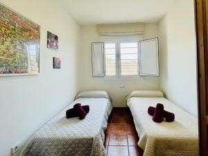 two beds in a room with two burgundy pillows at Casa Albons by Costabravaway in Albóns