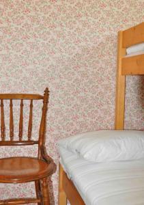 - une chambre avec un lit et un fauteuil en bois dans l'établissement Stuga i vassemåla, à Vimmerby