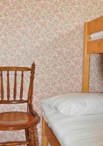 a bedroom with a bed and a wooden chair at Stuga i vassemåla in Vimmerby
