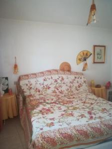 łóżko z kołdrą kwiatową w sypialni w obiekcie casa vacanze calasetta w mieście Calasetta