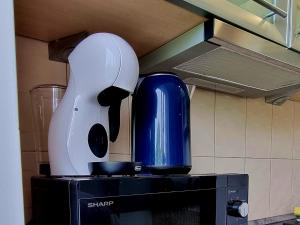 a white and blue blender sitting on top of a microwave at JAG apartamentai miesto centre in Šiauliai +10 photos