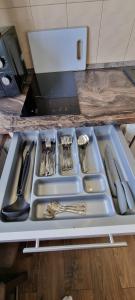 a tray with utensils in a kitchen sink at JAG apartamentai miesto centre in Šiauliai