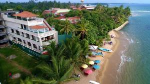 an aerial view of a hotel and a beach with umbrellas at Hotel Coconut Bar Sea Lodge in Beruwala