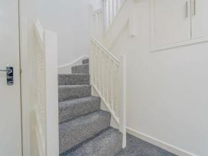 eine Treppe in einem Haus mit weißen Wänden und grauem Teppich in der Unterkunft Baltic Dockside Apartment, Free Parking in Liverpool