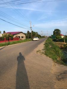 a shadow of a person walking down a road at Logerthine Josy Suriname in Paramaribo