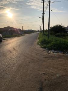 an empty road with the sun setting in the distance at Logerthine Josy Suriname in Paramaribo