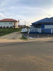 a white car parked in front of a house at Logerthine Josy Suriname in Paramaribo
