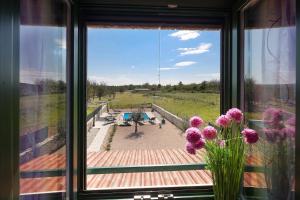 ein Fenster mit Blick auf eine Terrasse mit lila Blumen in der Unterkunft Villa Niko Your vacation starts here in Rudine
