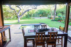 een eetkamer met een tafel en stoelen op een patio bij Braai Safaris Lodge in Hoedspruit