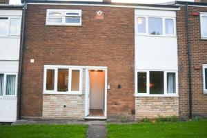 una casa de ladrillo rojo con puerta blanca en 2ndHomeStays- Willenhall-A Serene 3 Bed House with a Garden View-Suitable for Contractors and Families-Sleeps 9 - 7 mins to J10 M6 and 21 mins to Birmingham en Willenhall