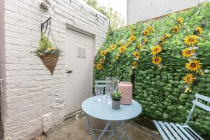 einen Tisch und Stühle vor einer Wand mit Sonnenblumen in der Unterkunft Historic Hideaway Waterford City in Waterford