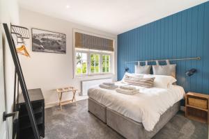 ein Schlafzimmer mit blauen Wänden und einem großen Bett in der Unterkunft The Queen Stage in Effingham