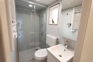 a bathroom with a shower and a toilet and a sink at Knus huisje op kindvriendelijk park met zwembad in Otterlo