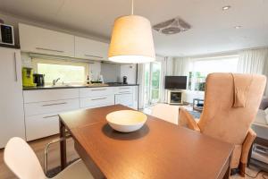 a kitchen with a wooden table with a bowl on it at Knus huisje op kindvriendelijk park met zwembad in Otterlo
