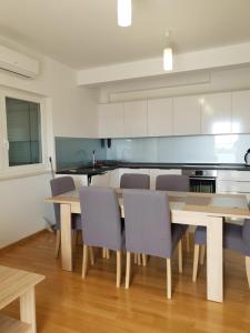 een keuken met een houten tafel en stoelen bij Sea View Apartments Zaboric in Zaboric