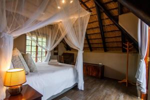 een slaapkamer met een hemelbed bij Braai Safaris Lodge in Hoedspruit
