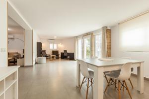 a kitchen and living room with a table and chairs at Loft Vallromanes in Vallromanes