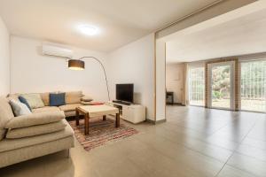 a living room with a couch and a tv at Loft Vallromanes in Vallromanes