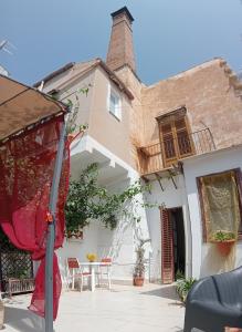 een huis met een tafel en stoelen ervoor bij Dietro il massimo in Palermo