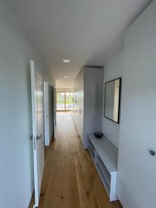 a hallway with white walls and a wooden floor at Vėtrungės apartamentai Svencelė in Svencelė