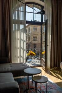 a living room with a couch and a large window at Gruner Hotel in Lviv