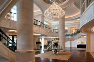 eine große Lobby mit einem Kronleuchter und einer Treppe in der Unterkunft The St. Regis Atlanta in Atlanta