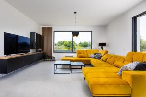 a living room with yellow couches and a tv at Villa Endless Summer in Sveti Anton