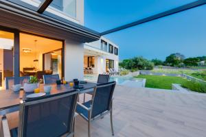 a patio with a table and chairs and a house at Villa Endless Summer in Sveti Anton