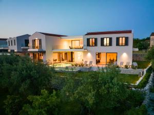 a large white house with its lights on at Villa Endless Summer in Sveti Anton