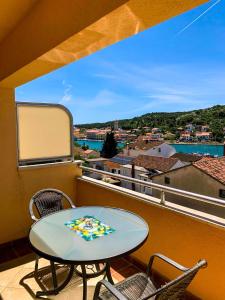 een tafel en stoelen op een balkon met uitzicht bij Sunny apartment Nada 2+1 #1 Tisno in Tisno