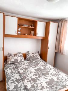 een kleine slaapkamer met een bed en houten kasten bij Sunny apartment Nada 2+1 #1 Tisno in Tisno