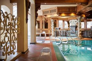 a swimming pool in a building with a table at Parkhotel Oberstaufen in Oberstaufen