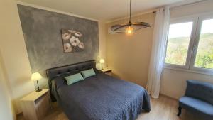 a bedroom with a bed and a chair and a window at Appartement Piovanacce - T3 avec pisicne privée 10min de Saint-Florent in Barbaggio +17 photos