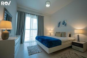 um quarto com uma cama e uma grande janela em Blissful 1BR with Pool and Creek view em Dubai