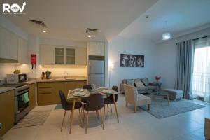 uma cozinha e sala de estar com mesa e cadeiras em Blissful 1BR with Pool and Creek view em Dubai