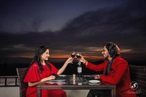 a man and woman sitting at a table drinking wine at Hotel Royal Ramesses - Katunayake in Seeduwa