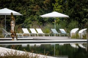 a group of chairs and umbrellas next to a pool at Villa Solatia in Caldogno