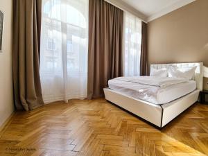a bedroom with a white bed and a large window at Appartement Cervantes 9 in Vienna