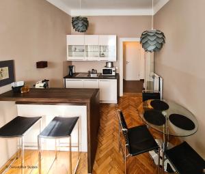 a kitchen with a counter and chairs and a table at Appartement Cervantes 9 in Vienna