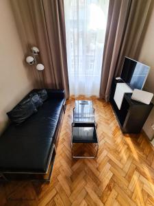 a living room with a black couch and a glass table at Appartement Cervantes 9 in Vienna