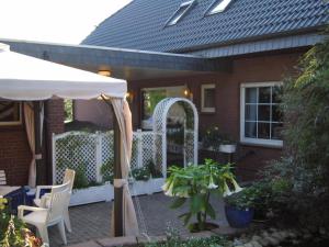 a house with a white fence and an umbrella at Ferienwohnung Beroma in Winsen