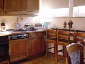 a kitchen with wooden cabinets and a stove top oven at Ferienwohnung Beroma in Winsen