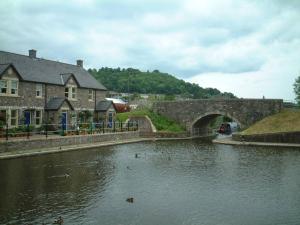 eine Brücke über einen Fluss mit Enten im Wasser in der Unterkunft Charming Brecon Beacons Cottage with Parking in Gilwern