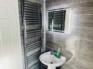 ein Badezimmer mit Waschbecken und Spiegel in der Unterkunft Charming Brecon Beacons Cottage with Parking in Gilwern + 18 Fotos