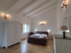 SUITE Rooms in Tenuta Asinara Vineyard في سورسو: غرفة نوم بسرير في غرفة بجدران بيضاء