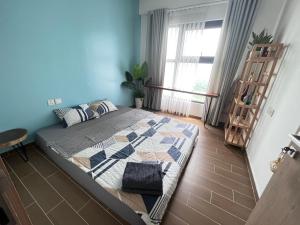 Schlafzimmer mit einem Bett mit blauer Wand in der Unterkunft 2 bed-rooms Apartment AquaSky, Ecopark, Hung Yen in HÆ°ng YÃªn
