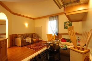 una cucina e un soggiorno con piano cottura di Hotel Lido - green & slow life a Molveno